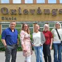 Foto av fem personer utanf&ouml;r en skolbyggnad. Fyra kvinnor och en man.